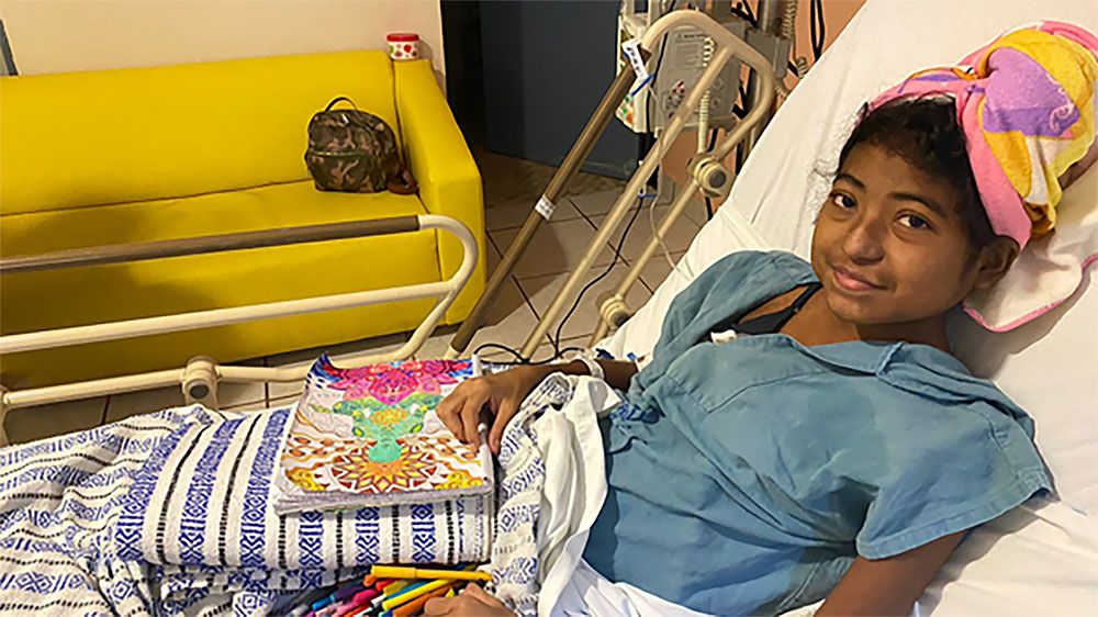 Child in bed with colouring materials